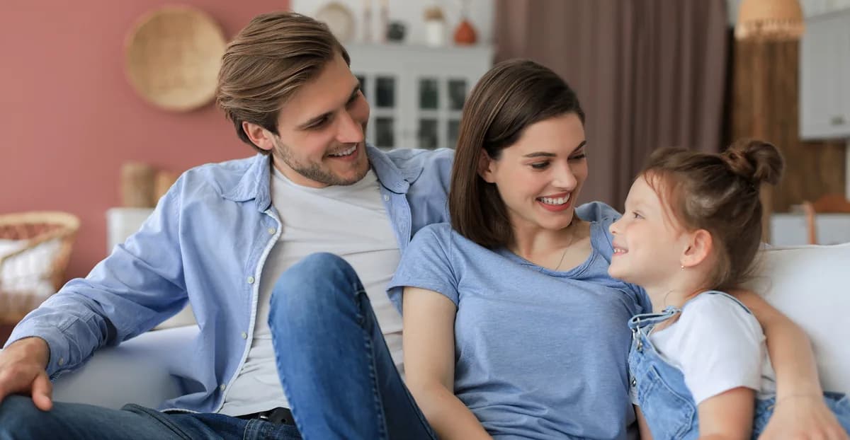 Família conversando e convivendo junta no sofá.